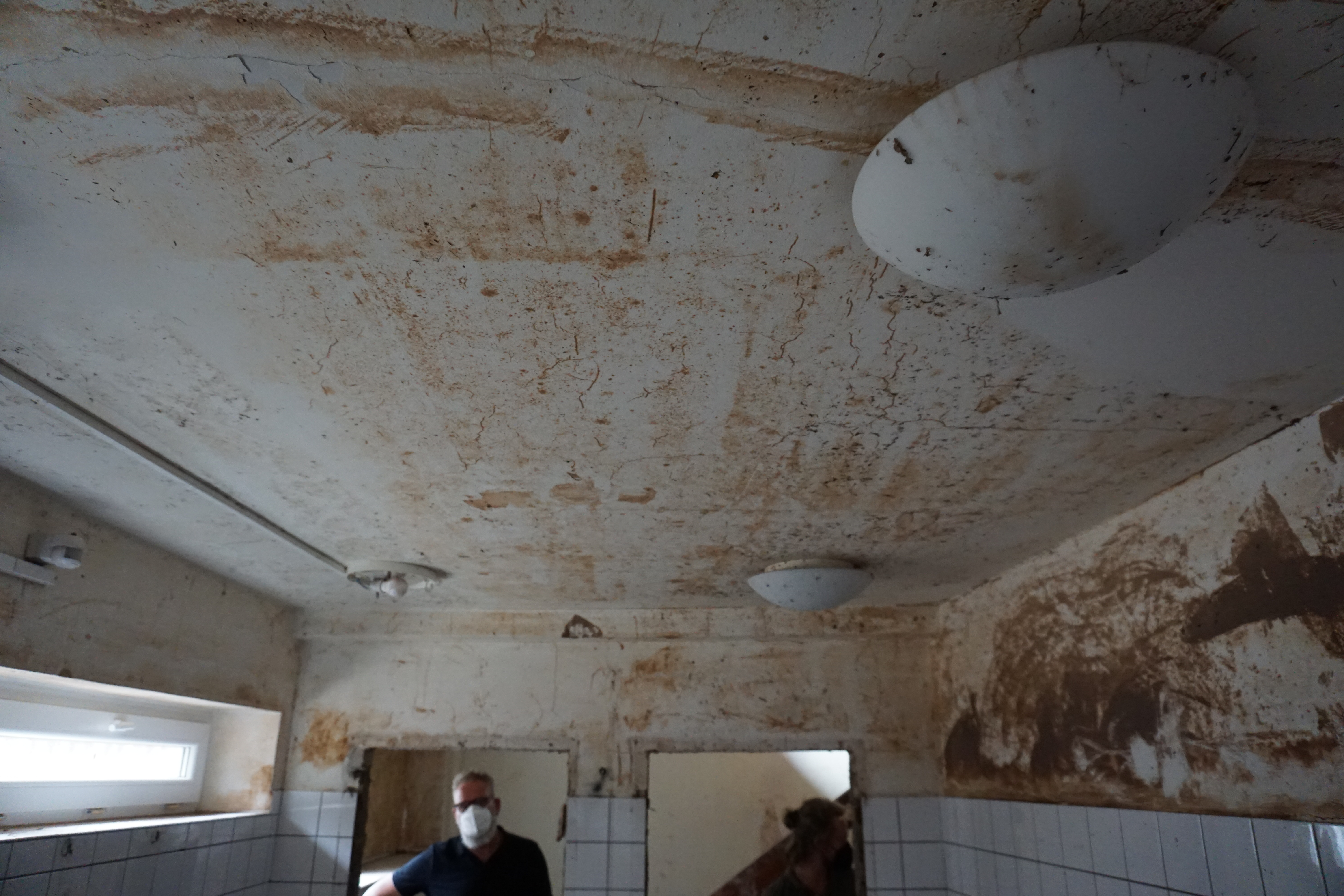 Schlammspuren und Wassersch&auml;den an Decke und W&auml;nden nach einem Starkregenereignis
